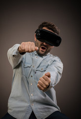 Young man driving in virtual reality wearing futuristic VR headset with copyspace on white background