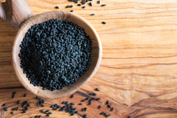 Black cumin seeds on a wooden spoon
