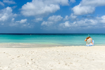 Fototapeta na wymiar A woman relax in the Eagle Beach, Aruba.