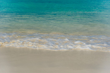 Fototapeta na wymiar Shiny tropic sea wave on golden beach sand in Aruba