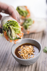 Thai vegetarian fresh rolls dipping in peanut sauce