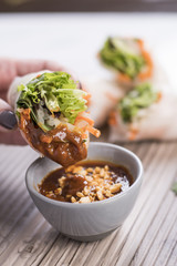 Thai vegetarian fresh rolls dipping in peanut sauce