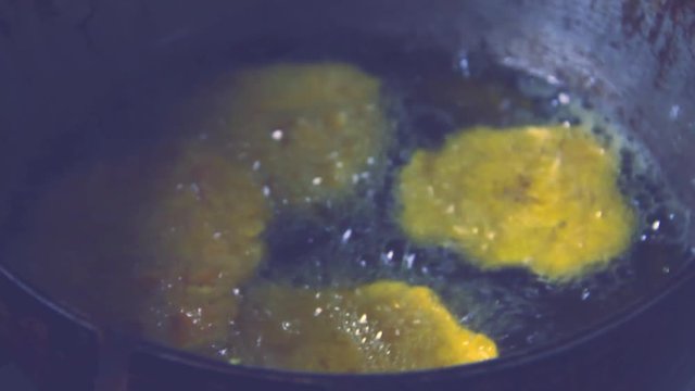Frying delicious and tasty Colombian plantain or cooking banana toasts in kitchen pan with golden oil