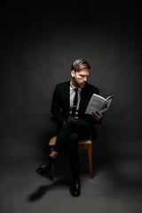 Man in suit reads a book