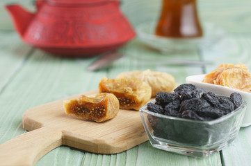 Oriental sweets, raisins, sesame, on a wooden background, tea