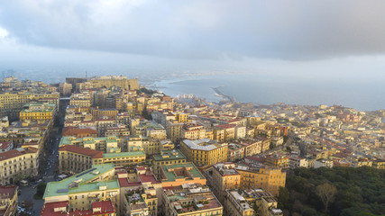 Obraz premium Aerial view of Naples from the Vomero district. You can see Castel Sant'elmo in the foreground while in the background the city's port, the Vesuvius and the Ovo castle. There are houses and buildings.