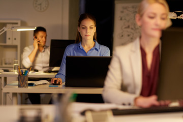 businesswoman at computer working at night office