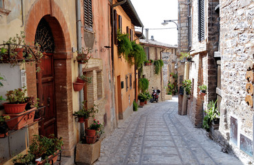 Fototapeta na wymiar Traditional italian medieval alley in the historic center of beautiful little town of Spello , in Umbria region - central Italy