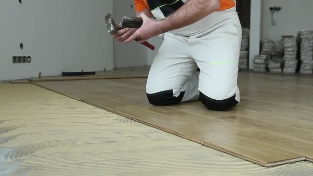 carpenter worker joining parket floor. slow motion