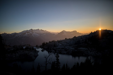 sunset over lake with mountain in the background