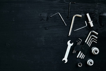 Flat lay of set of tools for car repairing such as wrenches on black wooden background. Top view.