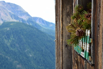 Almhüttenfenster mit Kieferzweige und Zapfen