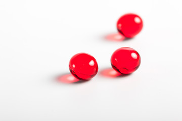 red capsules closeup on a white background. Medical background. Macro. tablets