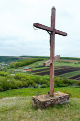 Fototapeta na wymiar Wooden cross near spring Rukomysh Cave temple, Ternopil Region, Ukraine.