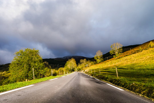 Beautiful empty road in Pyrenees. Autumn sunrise, shadows and colors of nature