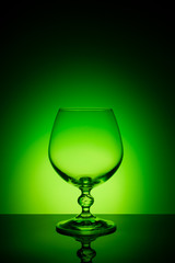 Wineglass on a color background with a black vignette. A tall Wineglass with a thin stalk