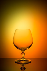 Wineglass on a color background with a black vignette. A tall Wineglass with a thin stalk