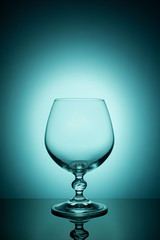 Wineglass on a color background with a black vignette. A tall Wineglass with a thin stalk