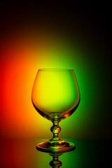 Wineglass on a color background with a black vignette. A tall Wineglass with a thin stalk