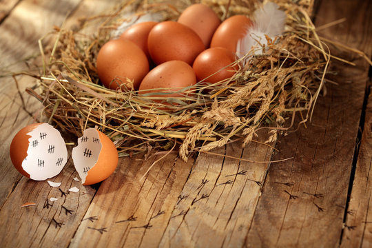 Chicken eggs in the nest. On wooden rustic background.Copy space