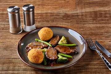 Stewed beef with vegetables on wooden background close up. Hot Meat Dishes. Top view