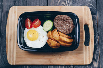 Breakfast/ Breakfast, lunch or dinner from fried eggs, tomatoes, cucumbers, slices of potatoes and meat cutlets.