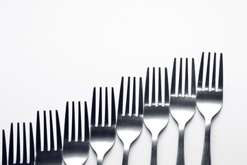 Fork background / A fork, in cutlery or kitchenware, is a tool consisting of a handle with several narrow tines on one end.