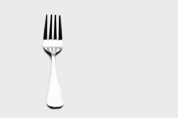 Fork background / A fork, in cutlery or kitchenware, is a tool consisting of a handle with several narrow tines on one end.