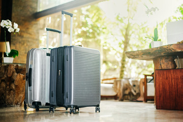 two gray large suitcases stand in the lobby of the hotel on the background of the waiting room and...