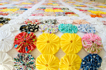 several pieces of Fuxico sewn together forming a bedspread. handmade. artisanal. craft. colorful.