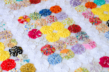 several pieces of Fuxico sewn together forming a bedspread. handmade. artisanal. craft. colorful.