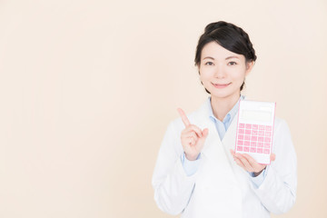 電卓を持つ白衣の女性