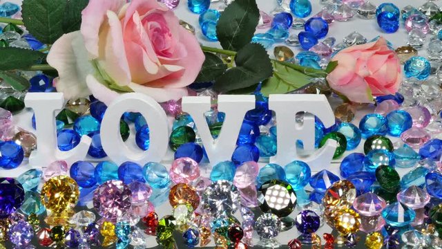 The white word love is located on the area of colorful diamonds and roses, the word love is love for Valentine's Day.

