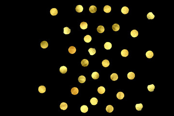 Golden confetti isolated on black background.