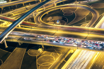 Fototapeta na wymiar Aerial view of big highway interchange with traffic in Dubai, UAE, at night. Scenic cityscape. Colorful transportation, communications and driving background.