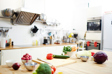 Variety of fresh vegetables on workplace of chef in the kitchen