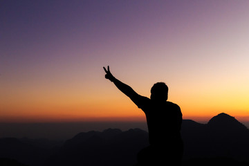 Man with arms extended toward heaven at sunrise ,success or prayer concept