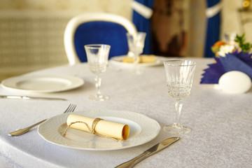 Cutlery on a table covered with a white tablecloth in a restaurant