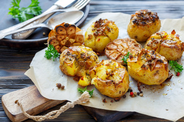 Baked potatoes in skin with spices, olive oil and garlic.
