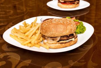 Plate with hamburger, french fries and sauce on the table at the bar.