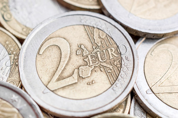Close up of 2 euro coin on heap of coins. Business and finance background. - obrazy, fototapety, plakaty