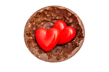 Two red hearts in half of big chocolate candy. Top view. Isolated on white.