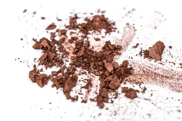 Brown crushed eye shadows on white background. Close up.
