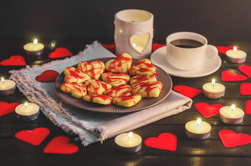 cookie-hearts, paper hearts, candles, boxes with presents and a Cup of black coffee, congratulation with Valentine's day.