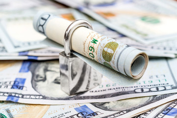Padlock on the background of dollar bills.