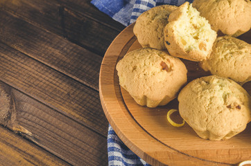 Lemon cupcakes on a wooden Board on the table with a blue towel.