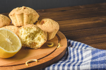 Lemon cupcakes on a wooden Board on the table with a blue towel.