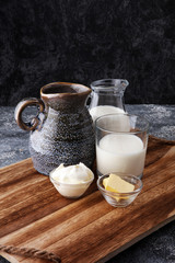 milk products - tasty healthy dairy products on a table sour cream in a bowl, cream and milk jar