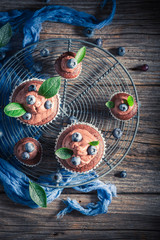 Obraz premium Pyszne muffinki z czekolady, świeżych jagód i śmietany