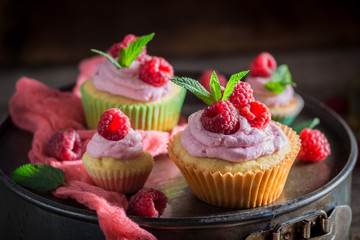Fresh and sweet raspberry muffin with berries and pink cream